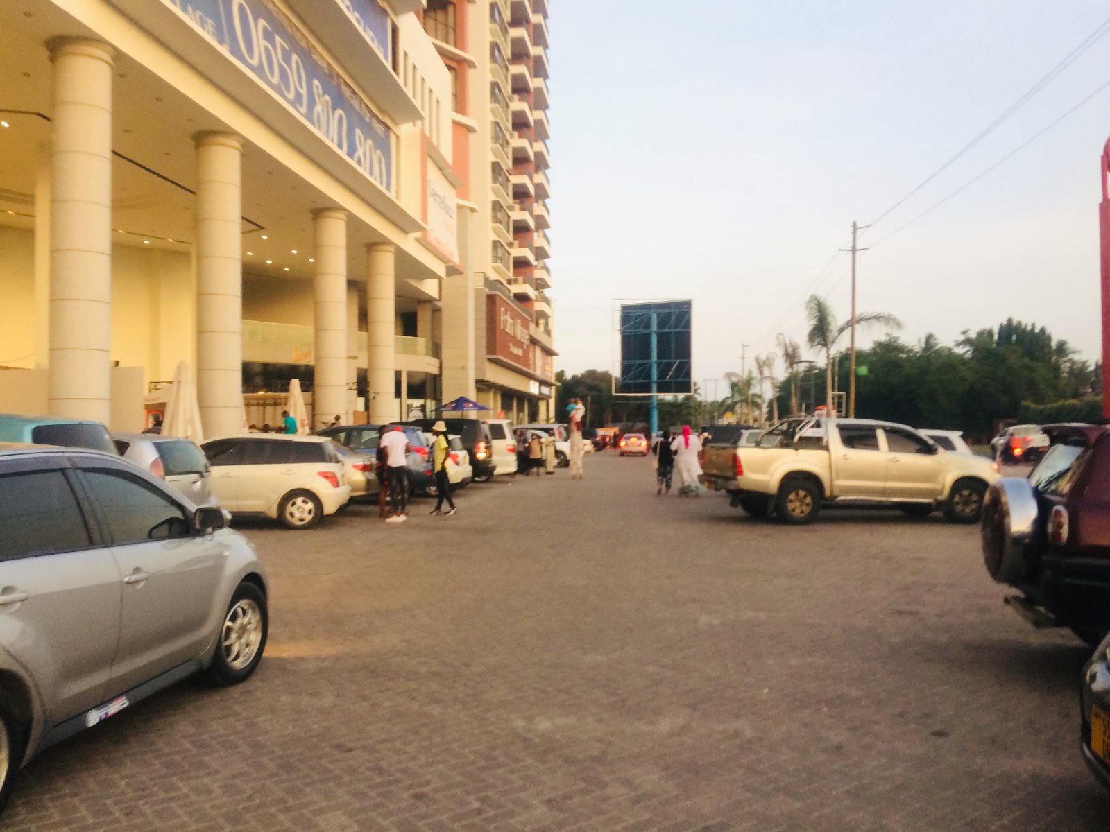 People in parking lot of Palm Village Mall in Dar Es Salaam, Tanzania