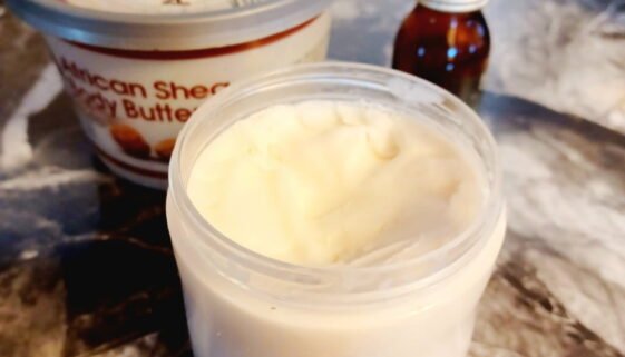 DIY natural skincare: small tub of homemade skincare cream with tub of shea butter and an essential oil bottle in background