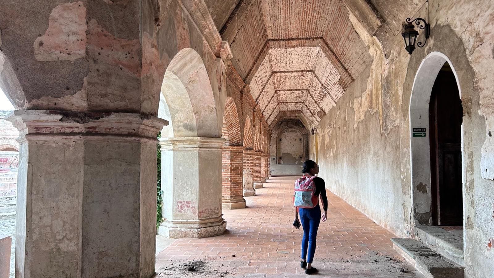 Curls Trip Travel Blog writer touring an old Catholic convent in Antigua Guatemala